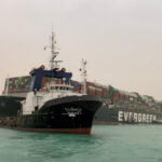 Remolcadores trabajan para reflotar un buque portacontenedores ultragrande que bloquea el canal de Suez